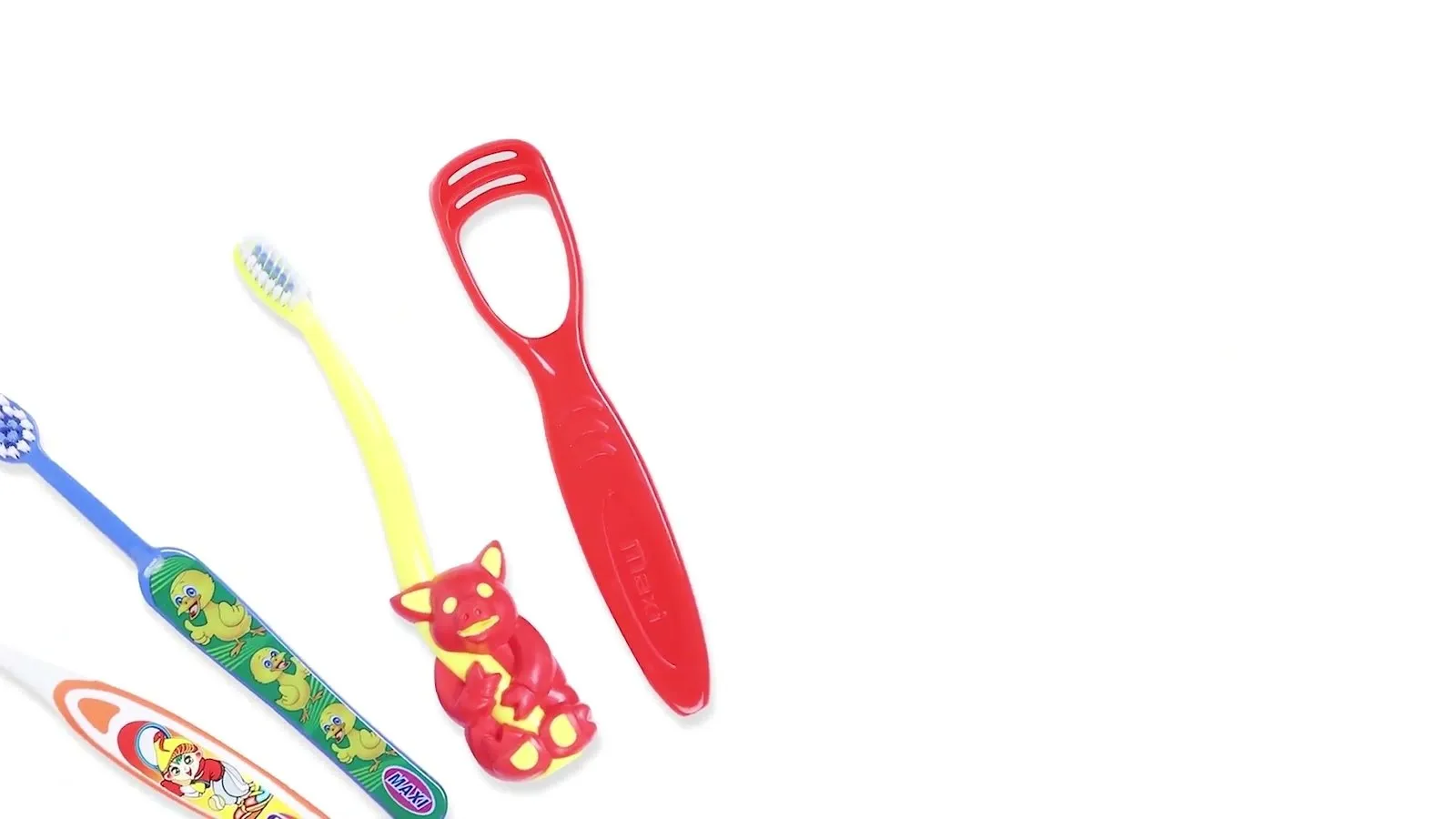 MAXI kids toothbrushes and tongue cleaners laid out on a white surface